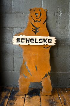 a wooden sign that says schleske with a bear on it's back