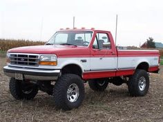 a red and white truck parked in a field