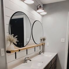 a bathroom with two sinks and three mirrors