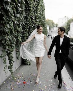 a bride and groom walking down the street