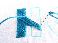 a close up of a piece of fabric with a needle and thread on the side