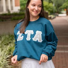 This unique & trendy Silver Glitter Greek Letter Sorority Chapter Gildan Crew Neck Sweatshirt is sure to stand out on any campus!  Grab one for you, your favorite sister, or a group of sisters (chapter discounts offered - see below for more information). Pictures Featuring:  1-3. Turquoise sweatshirt (discontinued color) w/ White background fabric color (Zeta Tau Alpha)  There are 4 parts to your Greek Letter Sweatshirt: 1. T-shirt Color 2. T-shirt Size 3. Background Fabric Letter Color - This i Sorority Long Sleeve Tops For College, Long Sleeve Tops For College Sororities, Sorority Crew Neck Tops For Fall, Sorority Style Letter Print Tops For Fall, Sorority Letter Print Tops For Fall, Stitched Sweatshirt, Greek Letter Shirts, Stitch Sweatshirt, Sorority Sweatshirts