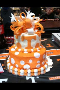 an orange and white polka dot cake on a table