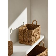 two baskets sitting on top of a white shelf