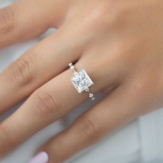 a woman's hand with a diamond ring on it