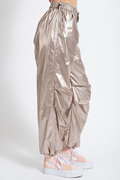 Take your style on an adventure with the Easel Metallic Parachute Cargo Pants in Champagne. Refined with ruched details, snap-button fastenings, and toggle ankle hems and waist, these pants provide a relaxed, loose fit that keeps you comfortable. With an elasticated waist for supreme freedom, you're ready to take on whatever comes your way! Material and Care 75% Nylon 25% Polyester Hand wash cold Hang to dry Measurements Small Waist:28" Length:41”  Inseam:30” Medium Waist:30"  Length:42” Inseam:31” Large Waist:32” Length:43” Inseam:32” Parachute Cargo Pants, Umgee Clothing, Parachute Cargo, Umgee Dress, Umgee Tops, Short Cardigan, Boutique Brands, Women Clothing Boutique, Small Waist