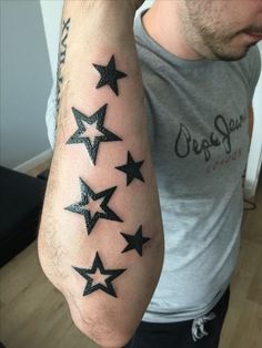 a man's arm with black stars on it