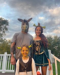 a man and woman standing next to a little boy wearing donkey masks on their heads