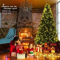 two children sitting in front of a christmas tree