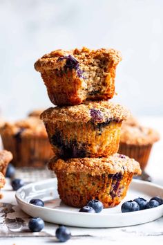 blueberry muffins stacked on top of each other with fresh blueberries around them