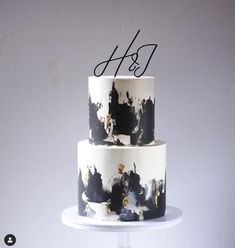 a three tiered cake with black and white paint splattered on it's sides