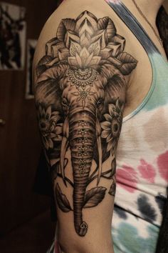 an elephant with flowers on it's back shoulder