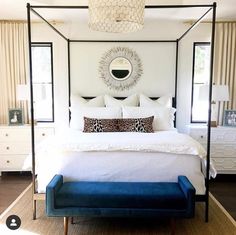 a bedroom with a four poster bed and blue bench in front of the bed,