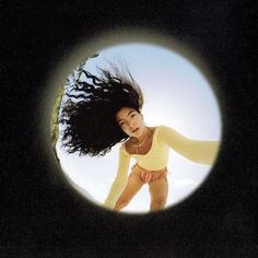 a woman with long hair is seen through a hole in the camera's lens