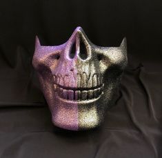 This half skull mask is hand painted purple and black and accented with a light glitter. Mask also has a elastic band and padding for a comfortable fit. Stand out and at your next costume party with unique skull mask. Mask size: 6"H x 7"W Purple Masks And Prosthetics For Halloween Masquerade, Purple Halloween Masquerade Masks And Prosthetics, Purple Mask For Costume Party, Black Rave Masks For Party, Purple Halloween Mask And Prosthetics, Half Skull Mask, Glitter Mask, Glitter Skull, Half Skull