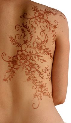 the back of a woman's body covered in hendix with flowers on it