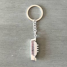 a metal keychain with the word, i love you in pink on it