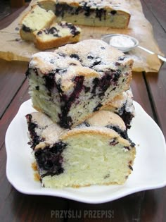 slices of blueberry coffee cake on a white plate with a wooden table in the background