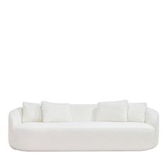 a white couch with four pillows on it