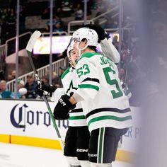 two hockey players congratulate each other on the ice