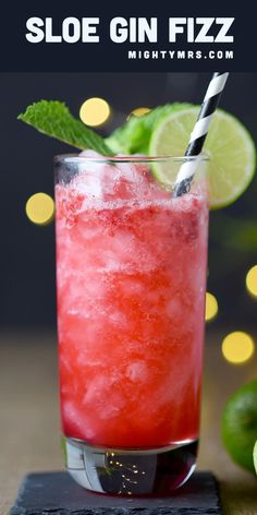 a red drink with limes and a straw in it