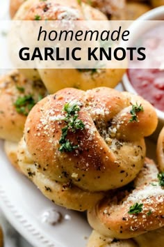 homemade garlic knots on a white plate with dipping sauce