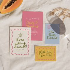 some cards that have been placed on top of a table with fruit and wine glasses