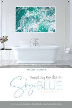 a white bath tub sitting under a painting on the wall