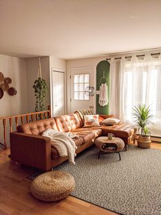 a living room filled with lots of furniture and decor on top of a hard wood floor