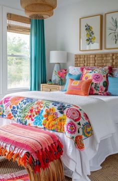 a bed with colorful pillows and blankets on top of it in a bedroom next to a window