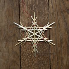 an ornament made out of toothpicks sitting on top of a wooden table