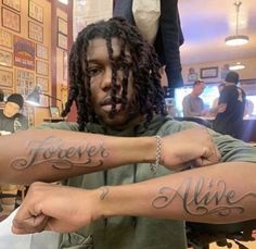 two people with tattoos on their arms that say forever and alive in cursive writing