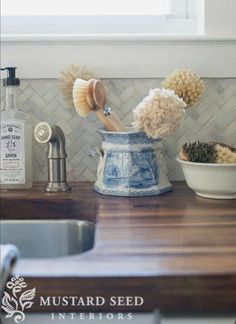 two pom - poms are sticking out of a blue and white pot on the kitchen counter