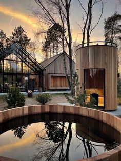 a wooden structure sitting in the middle of a forest next to a body of water