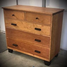 a wooden dresser sitting in a room next to a wall