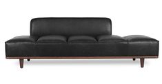 a black leather couch sitting on top of a wooden frame