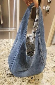 someone is holding an old pair of jeans in their hand while they are on the kitchen counter