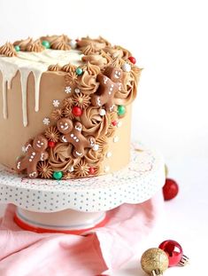 a chocolate cake with frosting and christmas decorations on top, sitting on a plate