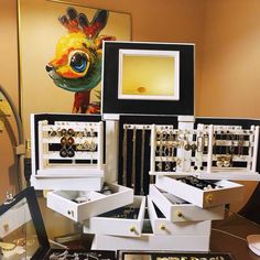 a table topped with lots of jewelry and framed pictures