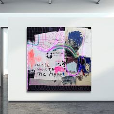 an abstract painting is hanging on the wall in a white room with concrete flooring