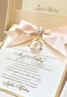 an open box with a pink ribbon and a brooch on it's side