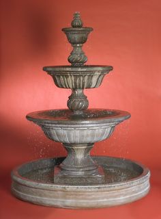 an old fountain with water spouting from it's sides on a red background