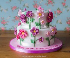 a white cake with pink and purple flowers on it