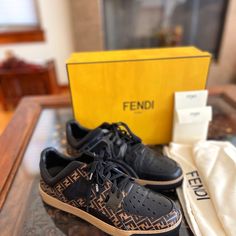 Fendi' (New In Box) Light Brown And Black Calf Leather Lace-Up Ff Logo Sneakers, These Feature A Round Toe, Decorative Perforations, A Branded Insole And A Flat Sole. Made In Italy Composition Lining: Calf Leather 100% Outer: Calf Leather 100%, Polyamide 100%, Polyester 100%, Pvc 100% Sole: Rubber 100% Designer Style Id: 7e1204a63j Fits Size 10-11 Men’s Designer Sneakers With Contrast Sole, Designer Sneakers With Perforations, Designer Brown Calf Leather Sneakers, Fendi Men, Box Light, Ff Logo, Designer Style, Leather Lace, Leather And Lace