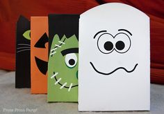 three halloween treat bags with faces on them