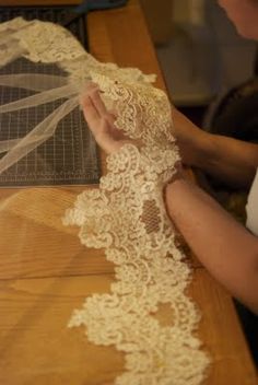 a woman is working on something with lace