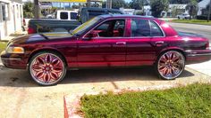 a maroon car parked in front of a gas station