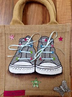 a handbag with a pair of shoes painted on the front and side, sitting on top of a wooden table