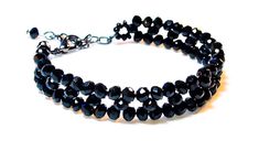 This uniquely designed bracelet is hand-beaded with gorgeous, shimmering Black AB 4mm crystals. It is finished with a gunmetal lobster clasp, and an extender chain for a perfect, adjustable fit. Fits Bracelet Sizes 6 ½ - 7 ½ (approximate). Standard woman's bracelet size is 7. Makes a perfect gift for any special occasion. Treat yourself or someone you love. *Please note the size of the beads in photo 2. All of my items are handmade with care and extra attention to detail and quality. FREE SHIPPI Luxury Black Elegant Beaded Bracelets, Cheap Black Beaded Crystal Bracelet, Cheap Themed Black Bracelets, Handmade Black Crystal Bracelet, Black Crystal Bracelet With Spacer Beads For Gift, Black Crystal Bracelet With Spacer Beads, Black Crystal Bracelet With Spacer And Round Beads, Black Crystal Bracelet With Faceted Beads For Party, Black Faceted Beads Crystal Bracelet For Party