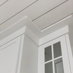 the corner of a room with white painted walls and trimmings on the ceiling